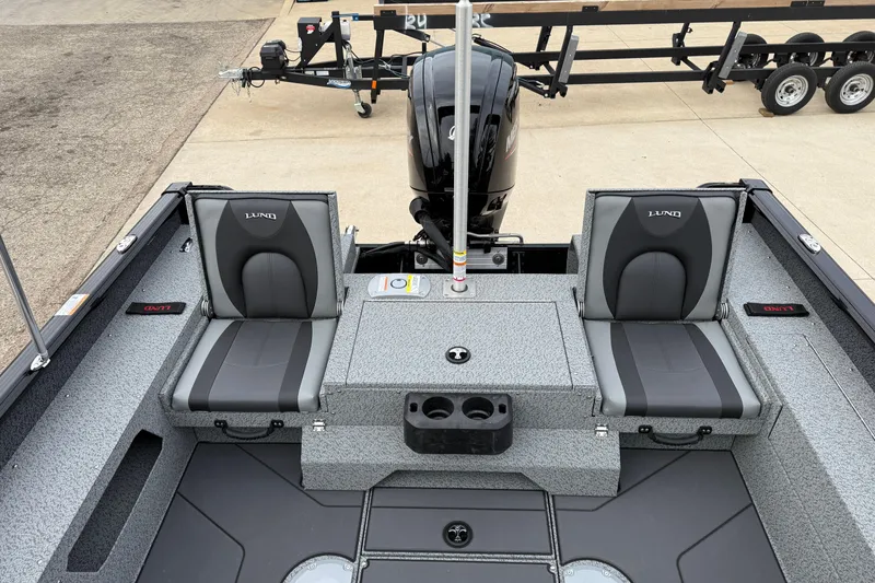Slide: The Image of 2026 Lund 1775 Impact XS Sport boat interior with seating and motor, parked on a trailer. - 24