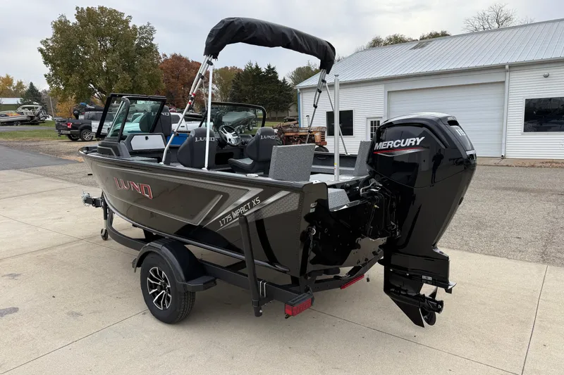 Slide: The Image of 2026 Lund 1775 Impact XS Sport boat with Mercury engine, parked outdoors. - 4