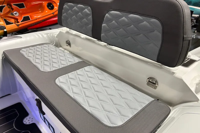Slide: The Image of 2026 Highfield Sport 390 boat interior with diamond-stitched gray seating and orange kayak in background. - 14