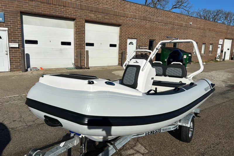 Slide: The Image of 2026 Highfield Sport 390 boat on trailer, parked outside brick building. - 2