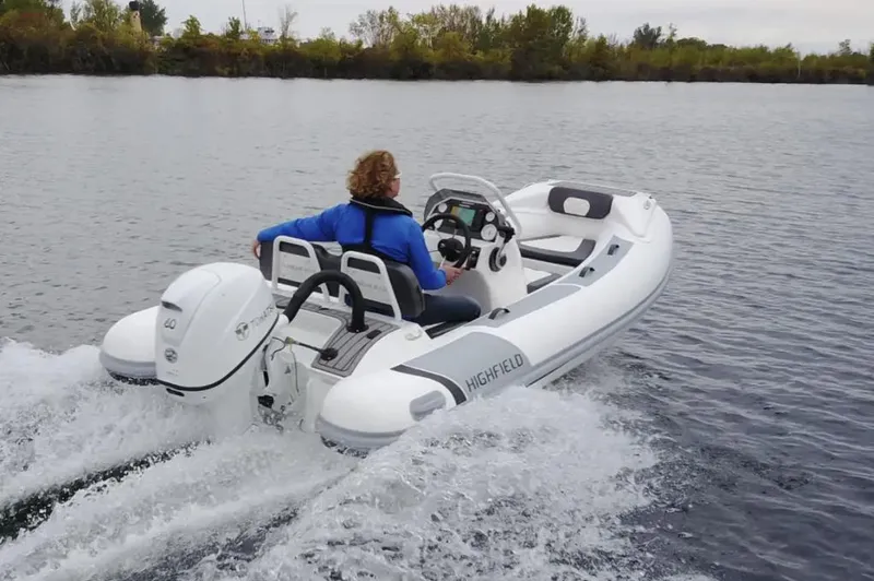 Slide: The Image of Manufacturer Provided Image: 2025 Highfield Sport 390 boat cruising on a lake with a person steering. - 4