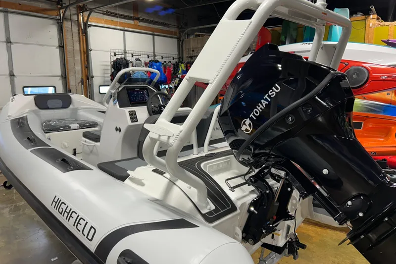 Slide: The Image of 2026 Highfield Sport 390 boat with Tohatsu outboard motor in a showroom. - 7