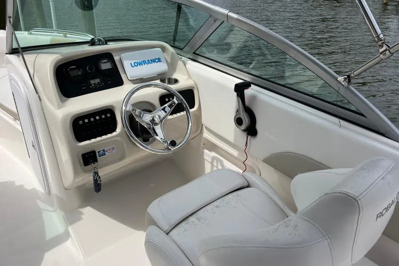 Slide: The Image of 2015 Robalo R227 Dual Console boat interior with steering wheel and control panel. - 11