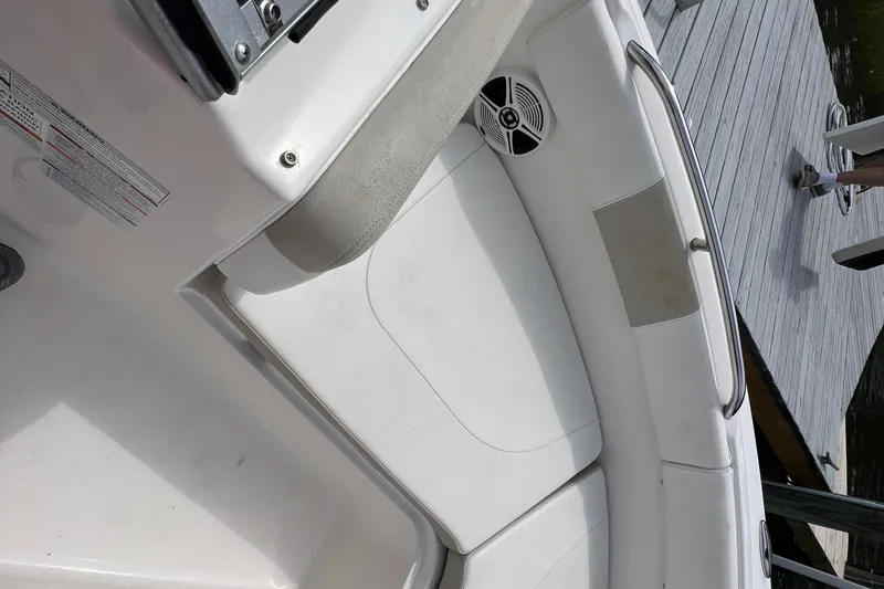 Slide: The Image of 2015 Robalo R227 Dual Console boat interior with white seating and speaker. - 18