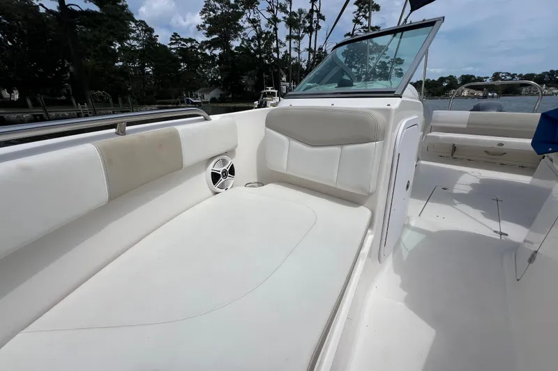Slide: The Image of 2015 Robalo R227 Dual Console boat interior with white seating and speaker. - 22