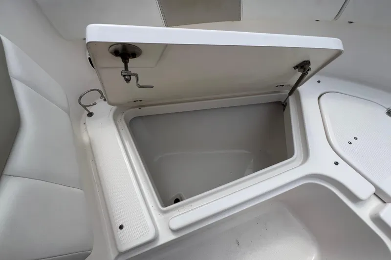 Slide: The Image of 2015 Robalo R227 Dual Console boat storage compartment open, showcasing interior space. - 27