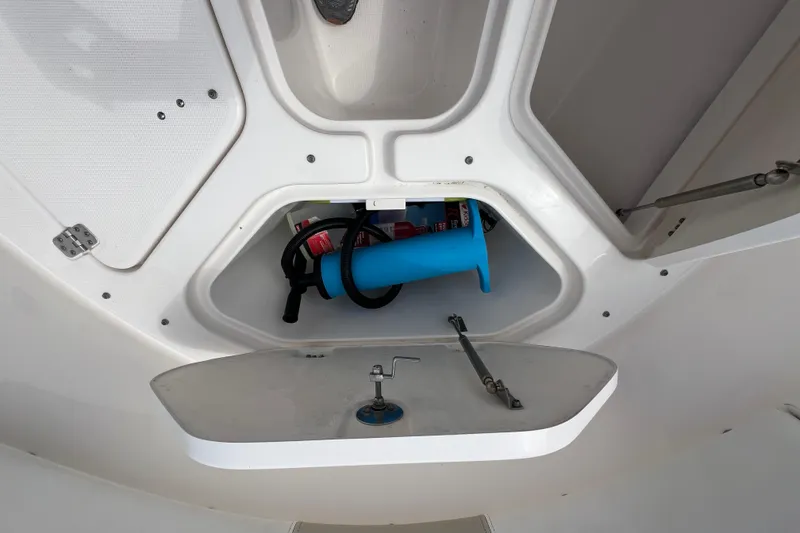 Slide: The Image of 2015 Robalo R227 Dual Console storage compartment with equipment and supplies. - 28