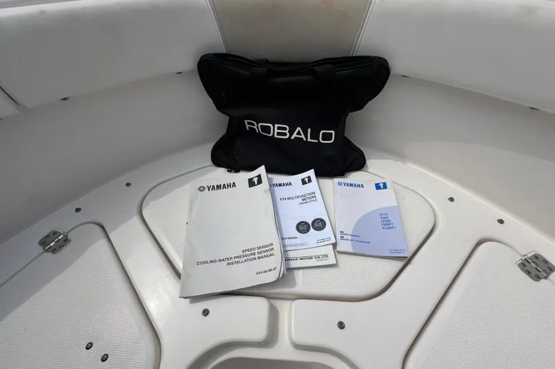 Slide: The Image of Robalo R227 Dual Console 2015 manuals and bag on boat deck. - 31