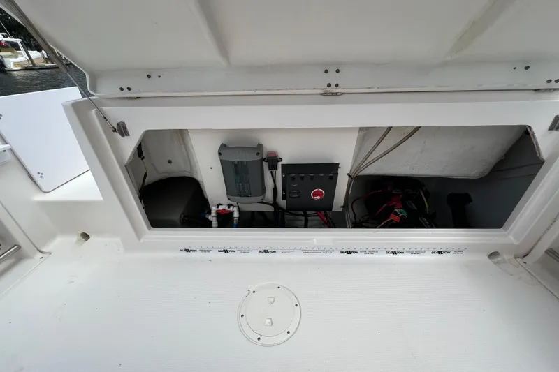 Slide: The Image of 2015 Robalo R227 Dual Console storage compartment with electrical components and wiring. - 43