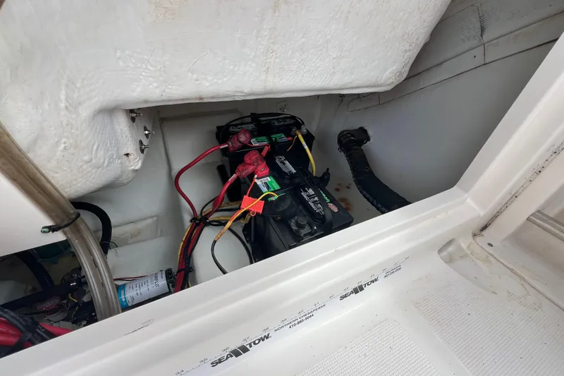 Slide: The Image of 2015 Robalo R227 Dual Console boat battery compartment with wiring and connections. - 44