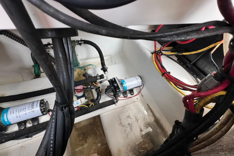 Slide: The Image of 2015 Robalo R227 Dual Console boat wiring and pump system in the engine compartment. - 46