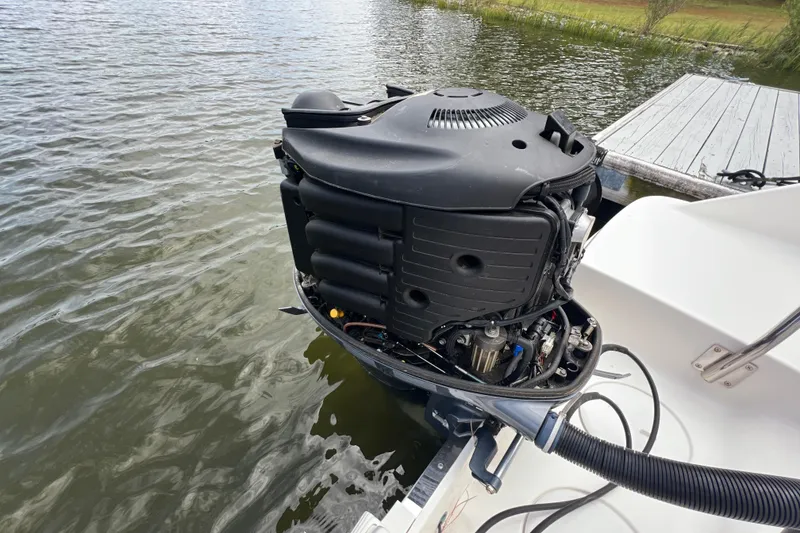 Slide: The Image of 2015 Robalo R227 Dual Console boat engine near dock on water. - 48
