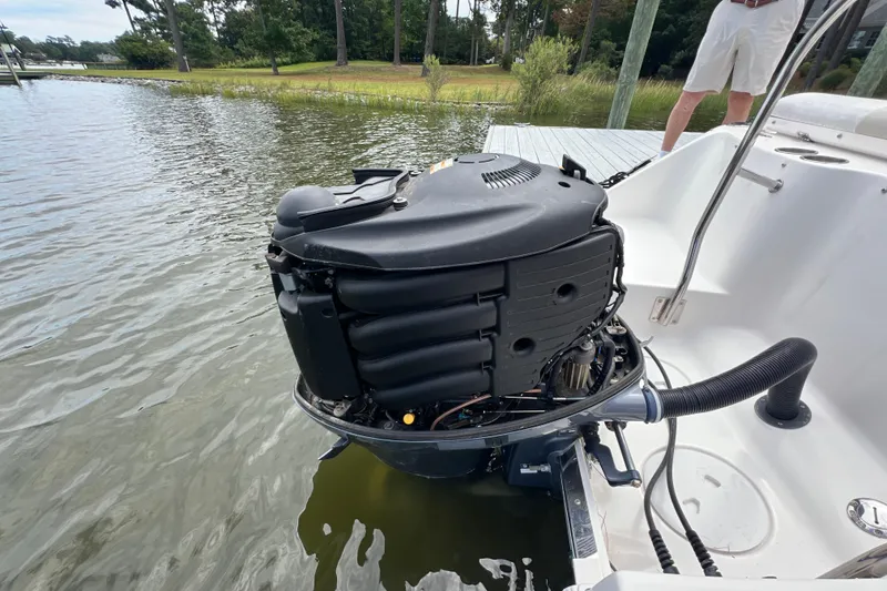 Slide: The Image of 2015 Robalo R227 Dual Console boat engine at dockside, partially submerged in water. - 49