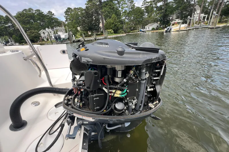 Slide: The Image of 2015 Robalo R227 Dual Console boat engine exposed on calm water. - 50