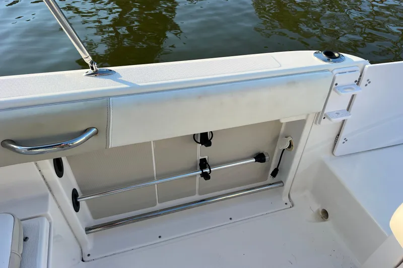 Slide: The Image of 2015 Robalo R227 Dual Console boat interior with stainless steel railing and storage compartment. - 56