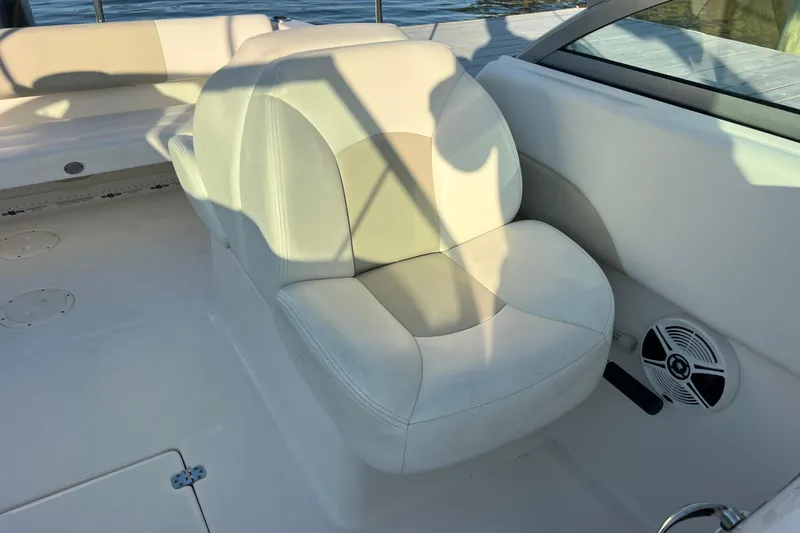 Slide: The Image of 2015 Robalo R227 Dual Console boat interior with white seating and speaker. - 59