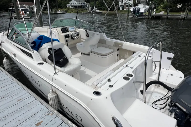Slide: The Image of 2015 Robalo R227 Dual Console boat docked, featuring spacious seating and modern controls. - 7