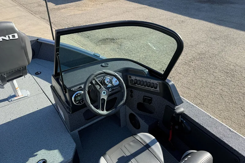 Slide: The Image of 2026 Lund 1775 Impact XS Sport boat interior with steering wheel and dashboard controls. - 16
