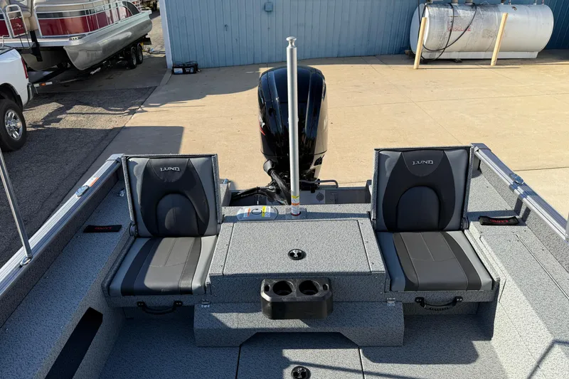 Slide: The Image of 2026 Lund 1775 Impact XS Sport boat interior with seating and motor, docked outdoors. - 24