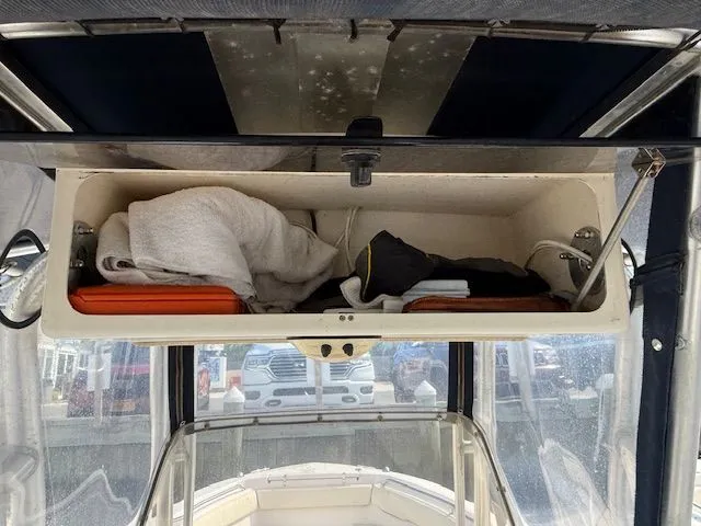 Slide: The Image of 2005 Grady-White Chase 273 boat storage compartment with towels and life jackets. - 12