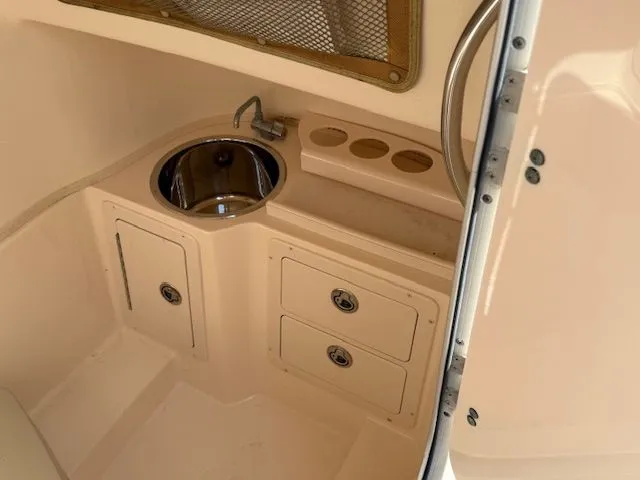 Slide: The Image of 2005 Grady-White Chase 273 boat interior with sink, storage, and cup holders. - 17