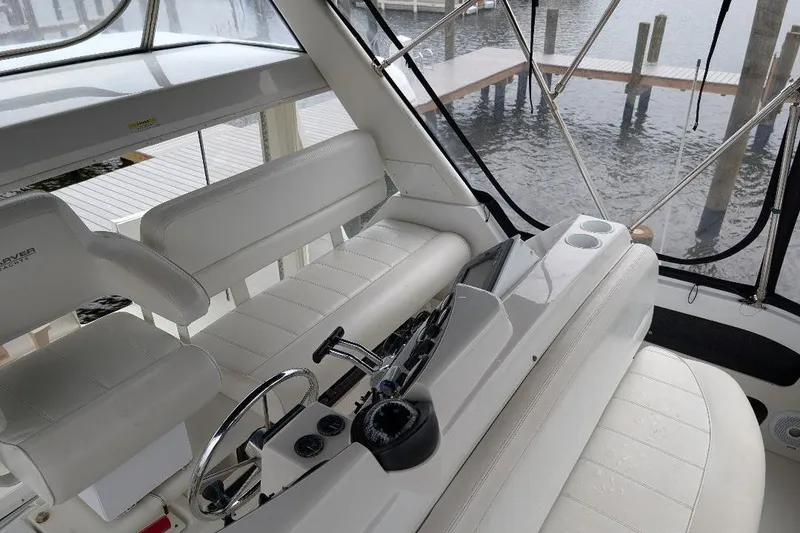 Slide: The Image of 2003 Carver 356 Motor Yacht interior with white seating and control panel, dockside view. - 14