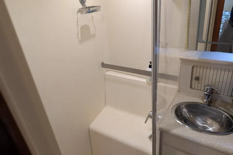 Slide: The Image of 2003 Carver 356 Motor Yacht bathroom with shower, sink, and mirror. - 26