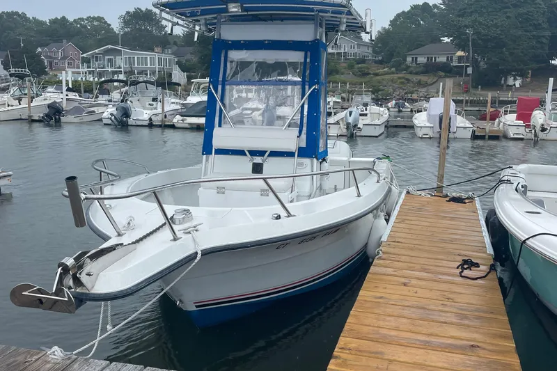 The Image of 1991 Four Winns 217 Quest boat docked at a marina with other vessels. - 1