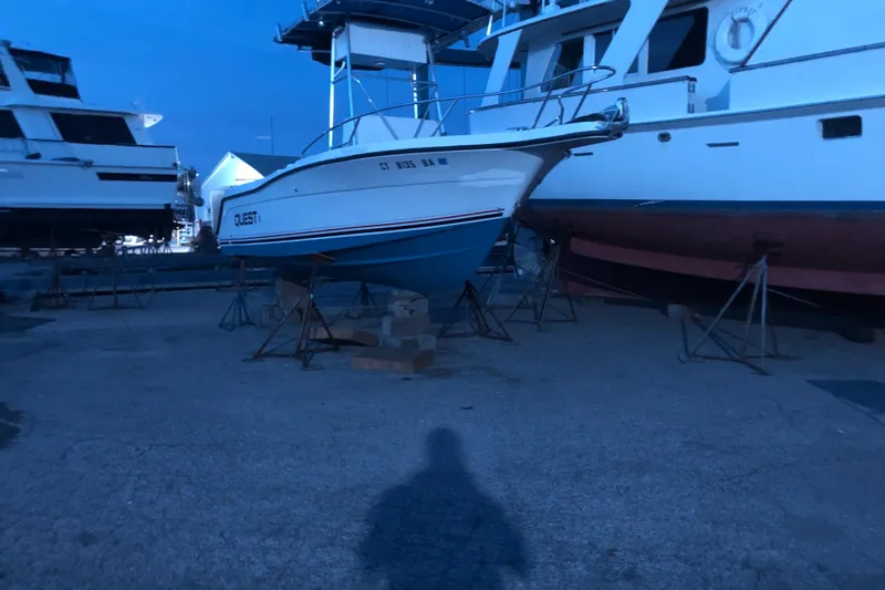 Slide: The Image of 1991 Four Winns 217 Quest boat on stands in a marina at dusk. - 10