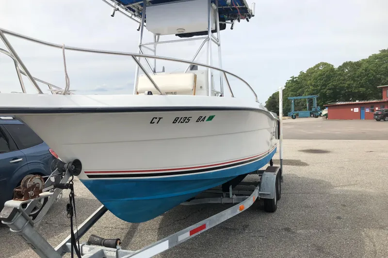 Slide: The Image of 1991 Four Winns 217 Quest boat on trailer in parking lot. - 14