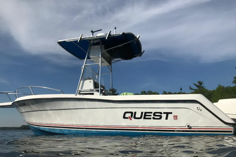 Slide: The Image of 1991 Four Winns 217 Quest boat on water, featuring a sleek design and blue accents. - 15