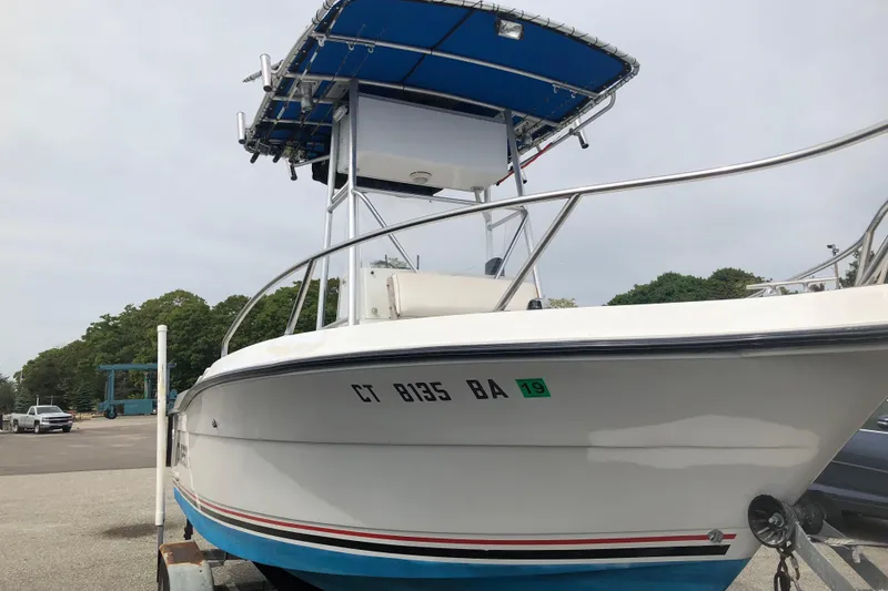 Slide: The Image of 1991 Four Winns 217 Quest boat with blue canopy, parked on a trailer. - 16