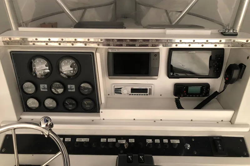 Slide: The Image of 1991 Four Winns 217 Quest boat dashboard with gauges, Garmin devices, and communication equipment. - 18