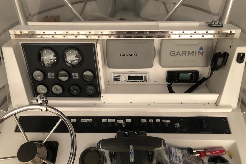 Slide: The Image of 1991 Four Winns 217 Quest boat dashboard with Garmin navigation and control instruments. - 20