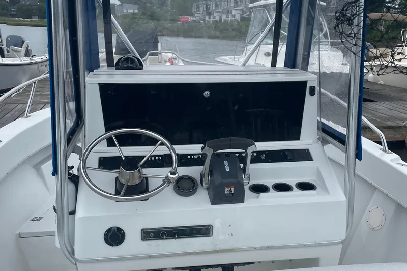 Slide: The Image of 1991 Four Winns 217 Quest boat dashboard with steering wheel and controls. - 4