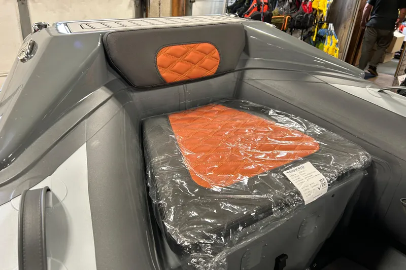 Slide: The Image of 2026 Highfield Sport 330 boat interior with orange quilted seat and protective plastic cover. - 3