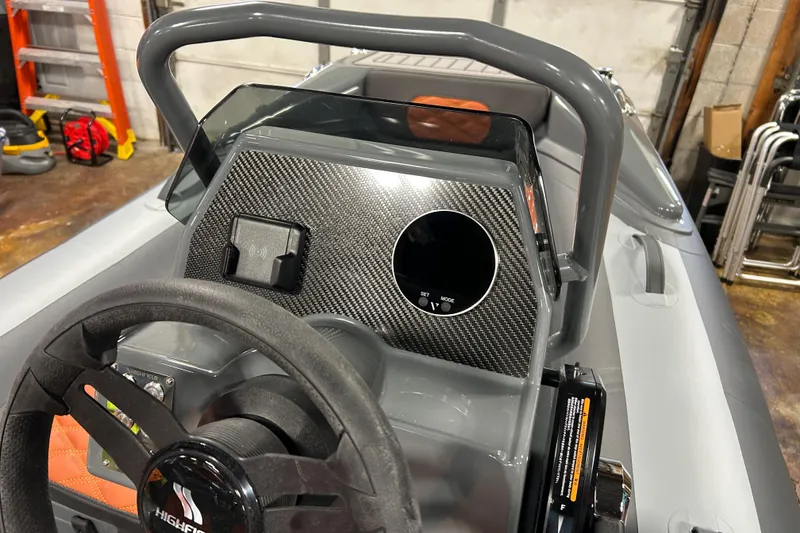 Slide: The Image of 2026 Highfield Sport 330 boat dashboard with carbon fiber finish and steering wheel. - 6