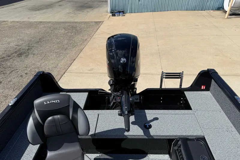 Slide: The Image of 2026 Lund 1800 Explorer Tiller boat interior with motor and seating. - 19