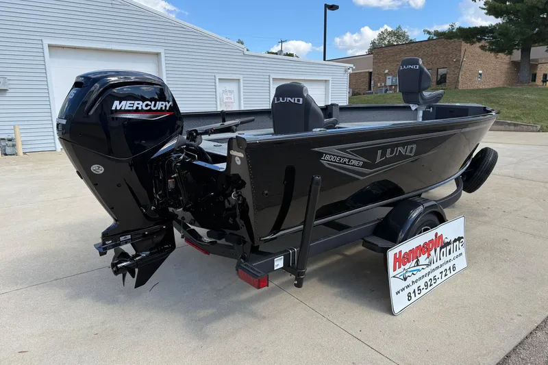 Slide: The Image of 2026 Lund 1800 Explorer Tiller boat with Mercury engine, displayed at Hennepin Marine dealership. - 7