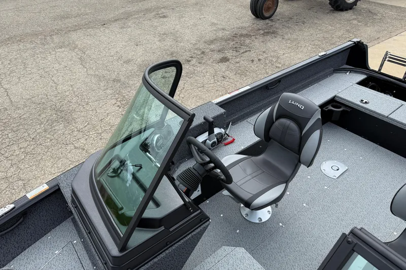 Slide: The Image of 2026 Lund 1800 Explorer Sport boat interior with steering wheel and seating. - 14