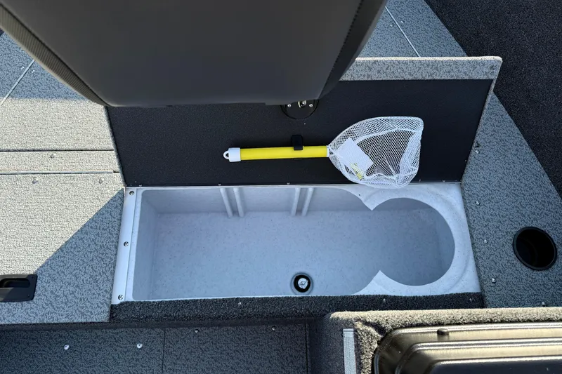 Slide: The Image of 2026 Lund 1650 Rebel XL SS boat interior with storage compartment and fishing net. - 10