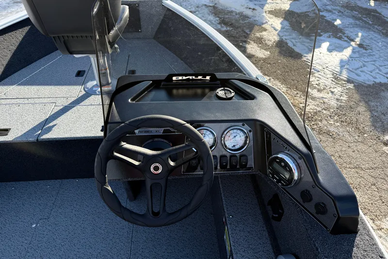 Slide: The Image of 2026 Lund 1650 Rebel XL SS boat dashboard with steering wheel and gauges. - 15
