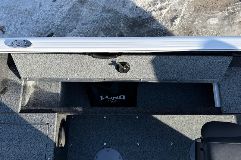 Slide: The Image of 2026 Lund 1650 Rebel XL SS boat interior with storage compartment and seating. - 23