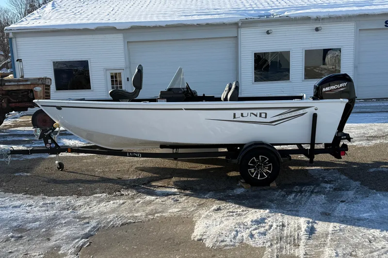 Slide: The Image of 2026 Lund 1650 Rebel XL SS boat on trailer, parked in snowy driveway. - 4