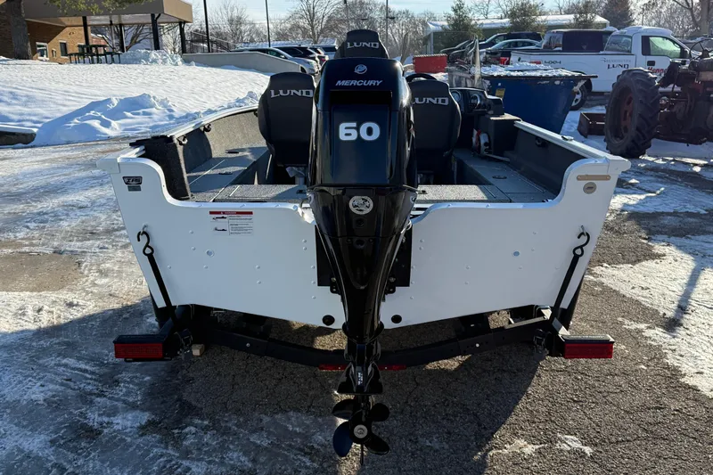 Slide: The Image of 2026 Lund 1650 Rebel XL SS boat with Mercury 60 engine, parked on snowy pavement. - 6