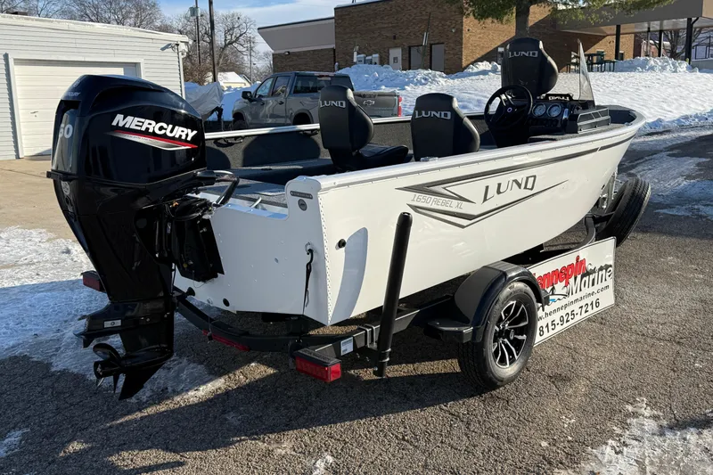 Slide: The Image of 2026 Lund 1650 Rebel XL SS boat with Mercury engine on a trailer in snowy setting. - 7