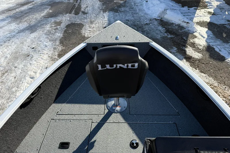 Slide: The Image of 2026 Lund 1650 Rebel XL SS boat interior with snow-covered ground in background. - 9