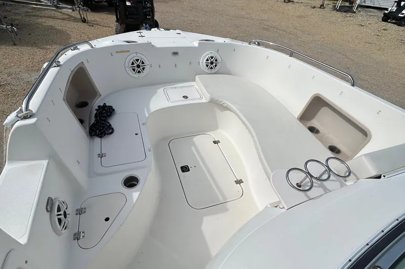 Slide: The Image of 2004 Hurricane SD 260 boat interior with seating, storage, and cup holders. - 2
