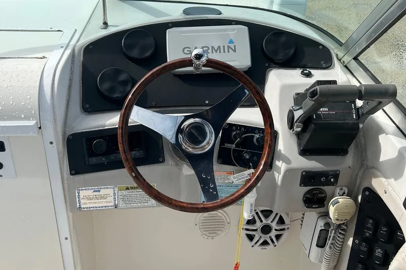 Slide: The Image of 2004 Hurricane SD 260 boat dashboard with Garmin GPS, steering wheel, and Yamaha controls. - 3
