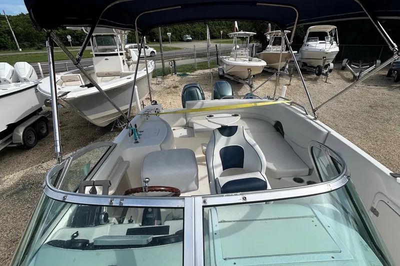 Slide: The Image of 2004 Hurricane SD 260 boat with seating and canopy, parked on gravel lot. - 4